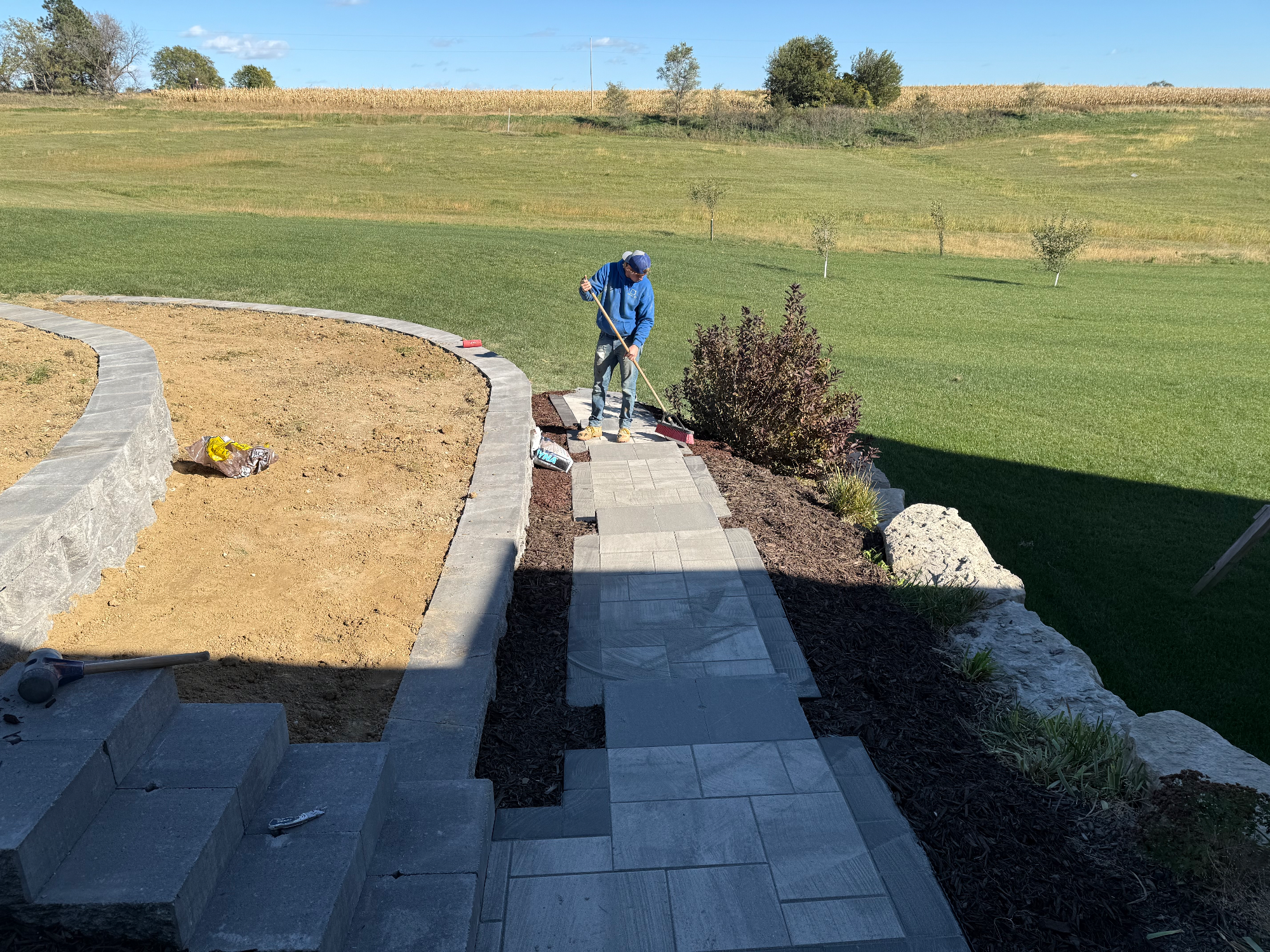 Curved paver walkway with retaining wall and professional landscaping