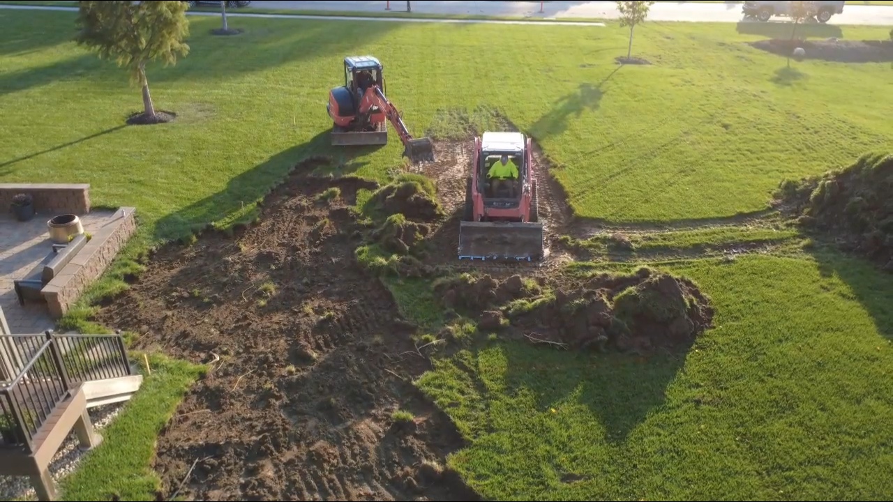 Pool with tiered stone retaining walls and slide in Nebraska backyard