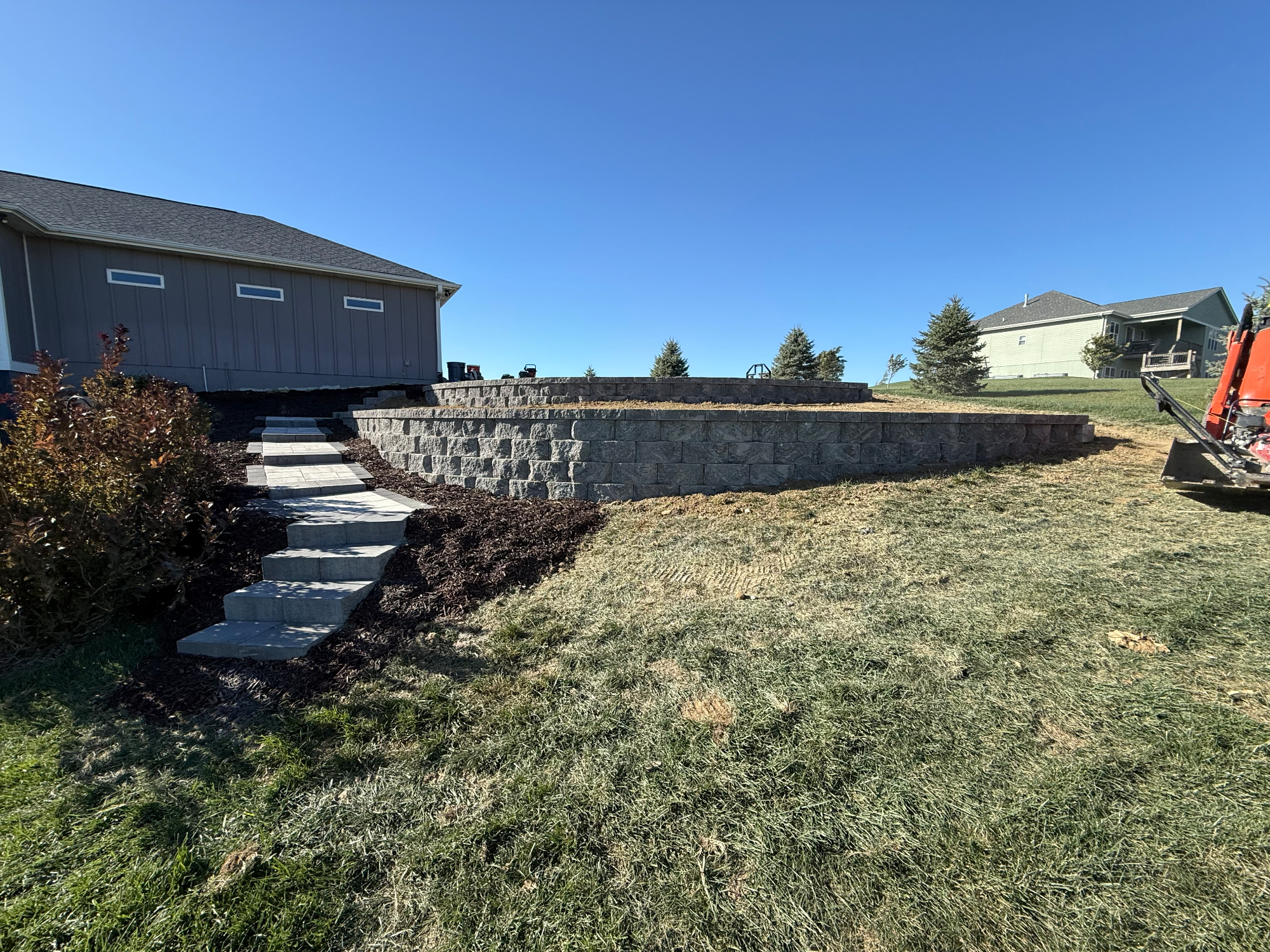 Block retaining wall with integrated steps and landscaping in Nebraska